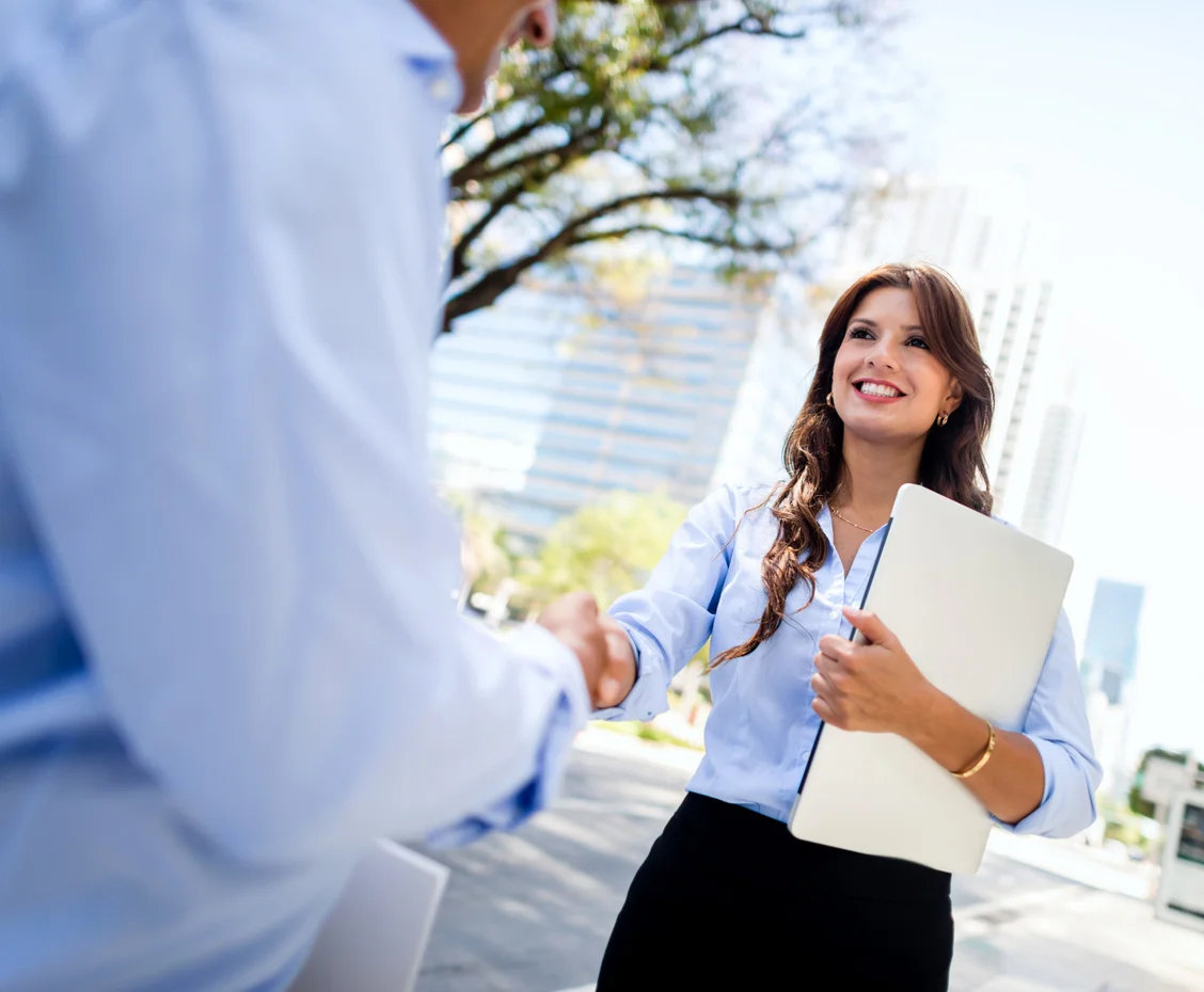 business-woman-shaking-hands-with-a-client-outdoors.webp