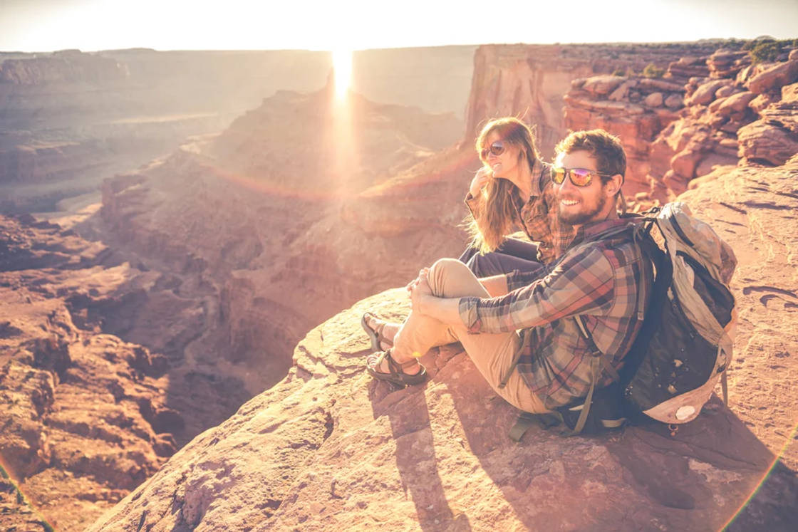 hikers-sitting-on-red-rocks-in-southern-utah.webp