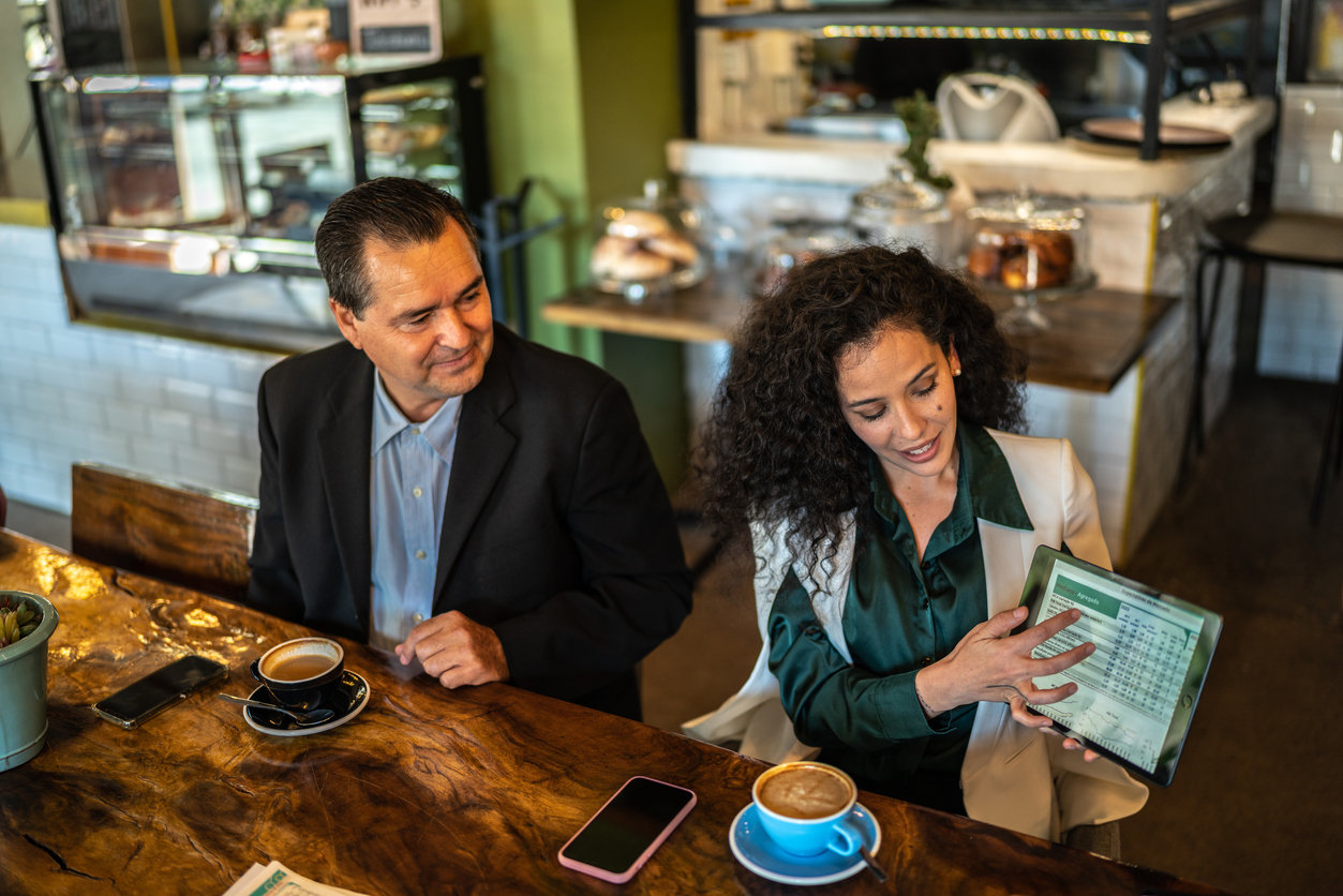 Mid adult businesswoman doing a presentation to coworkers at a coffee shop