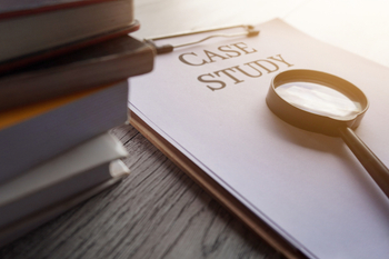 Paper clipboard with text, case study magnifying glass and books