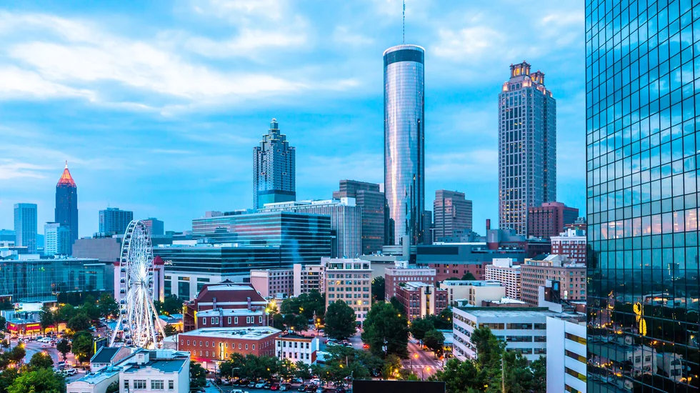 skyline-view-of-downtown-and-midtown-atlanta-with-ferris-wheel-from-a-rooftop-bar-and-lounge.webp