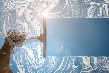 Window cleaner using squeegee to wash a window
