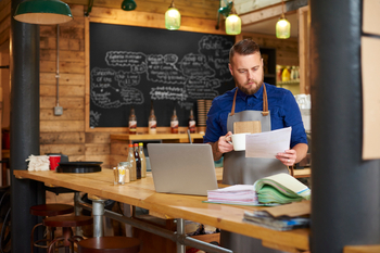 A man drinking coffee and checking accounts