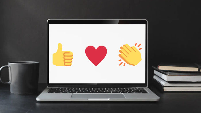 black and white laptop with three emojis, thumbs up, heart and clap