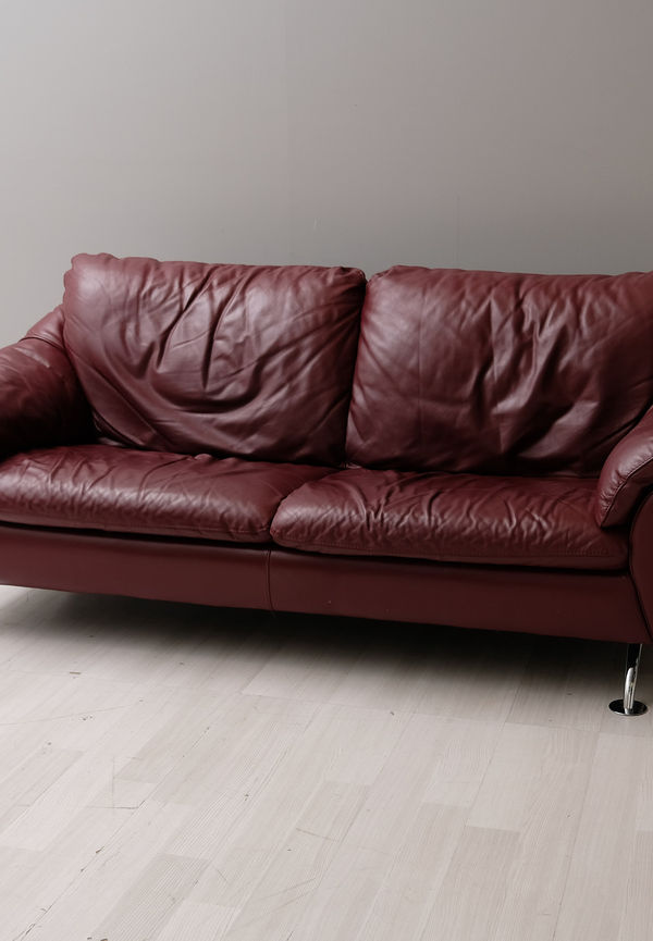 Mysig soffa i vinröd färg gjord i skinn.
