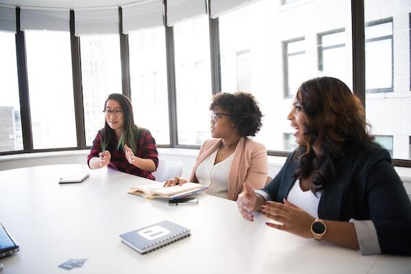 A group of diverse women having a discussion in a board room