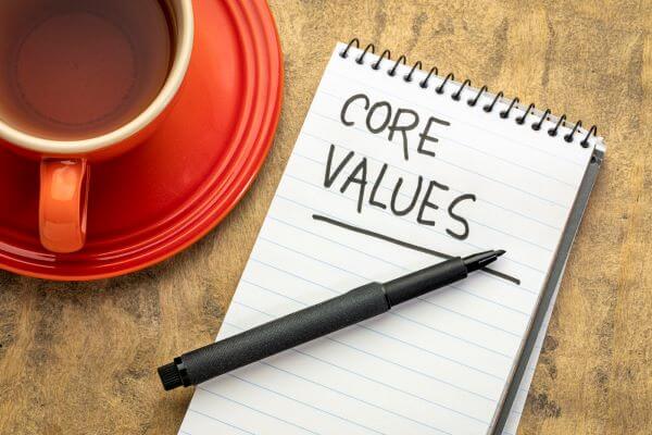 A notepad that says Core Values with a pen and coffee cup beside it.