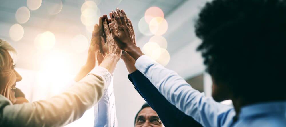 A group of diverse people giving each other a high five