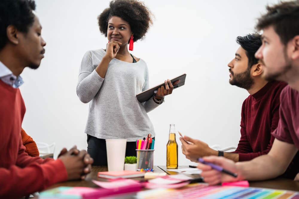 black woman leading a meeting with three guys 