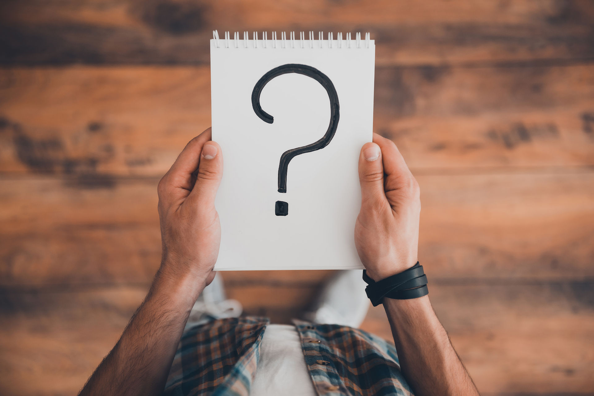 Man holding a notebook with a question mark