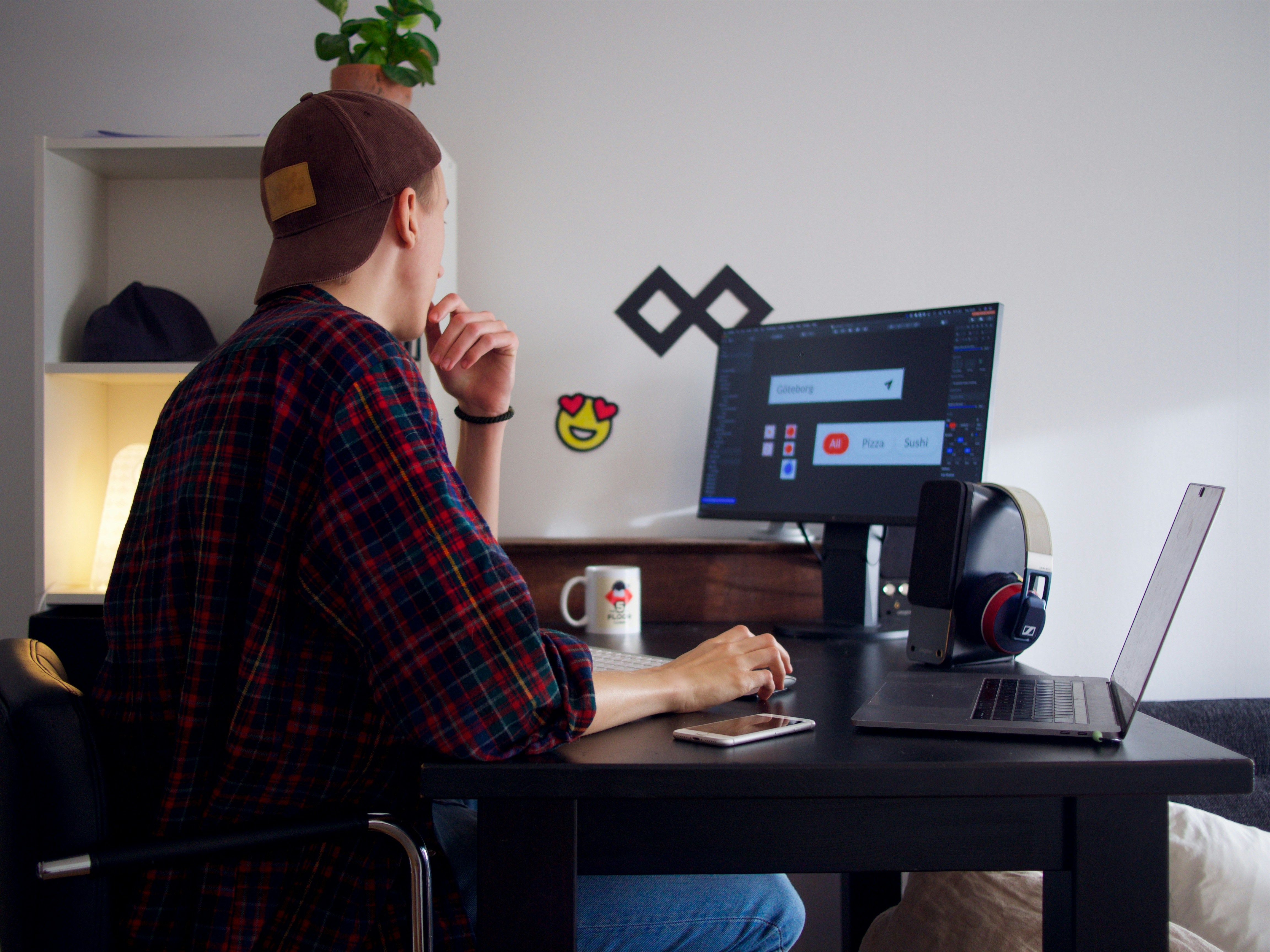 A freelancer at a laptop surrounded by AI interface visuals and glowing screens
