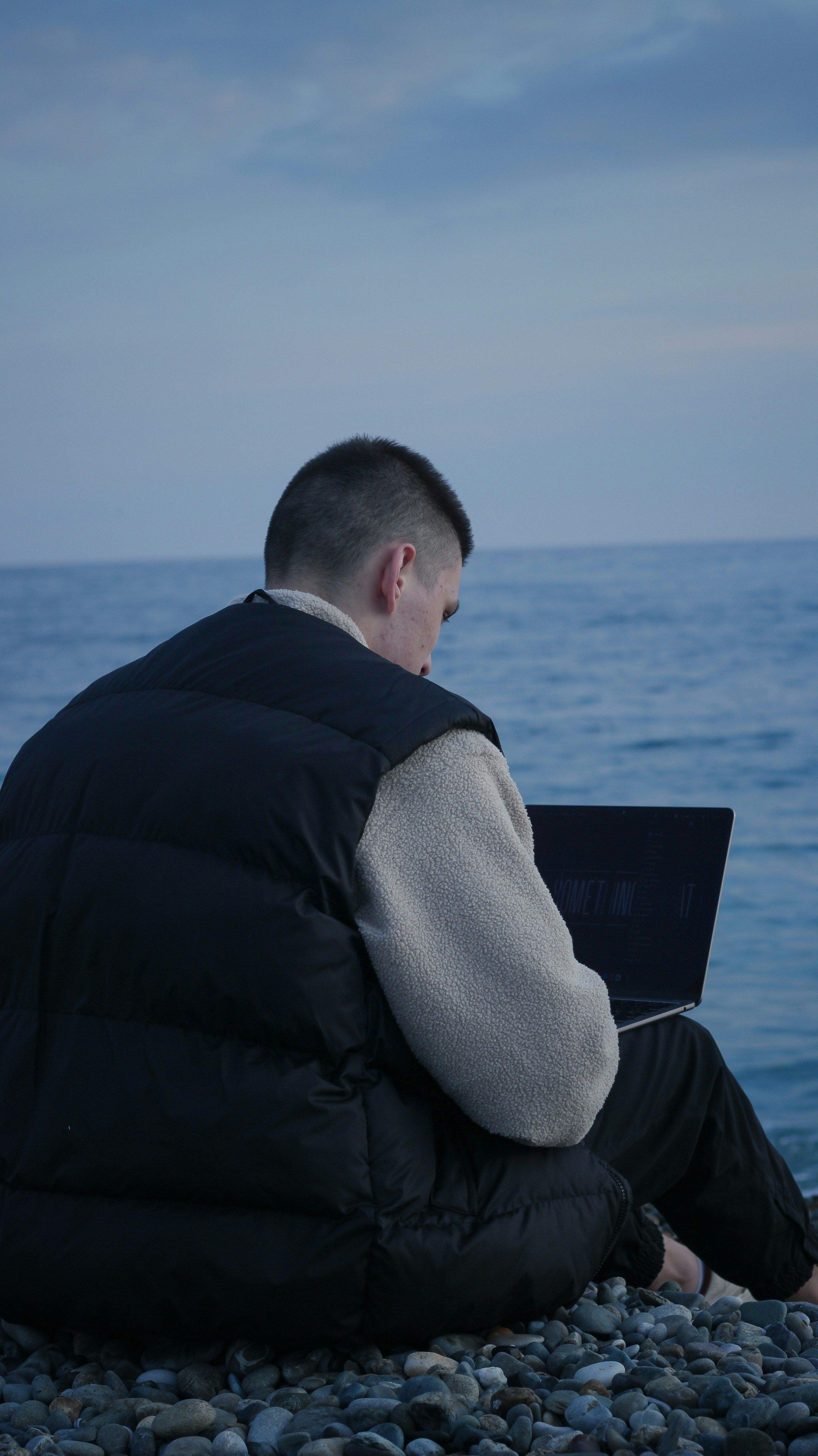 A freelancer working on a laptop at a clean desk with coffee and a notebook