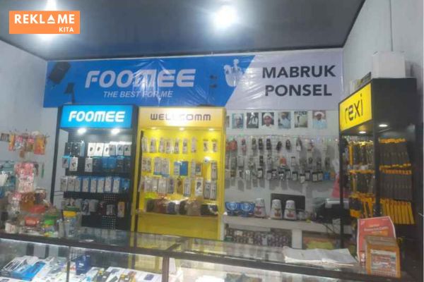 Contoh tampilan branding konter aksesoris HP dengan spanduk/banner di bagian atas.