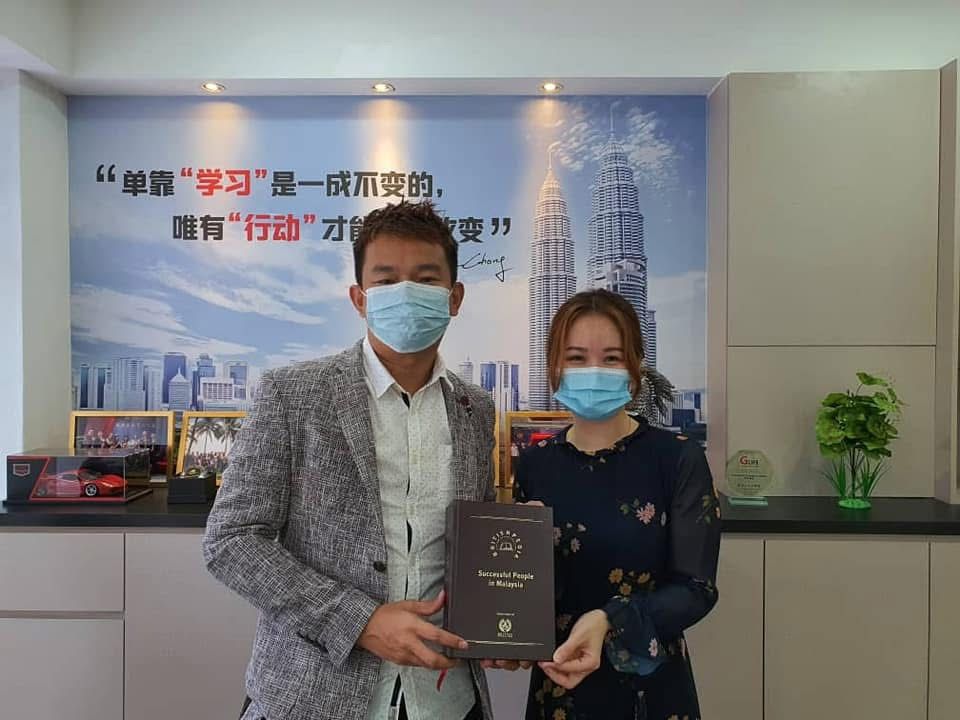 Terry Chong receiving the Successful People in Malaysia book from Britishpedia