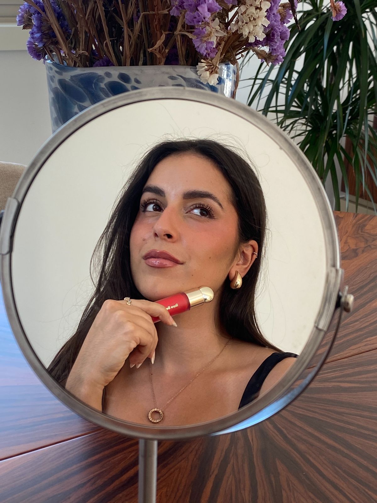 Maya holding Rare Beauty blush after applying it