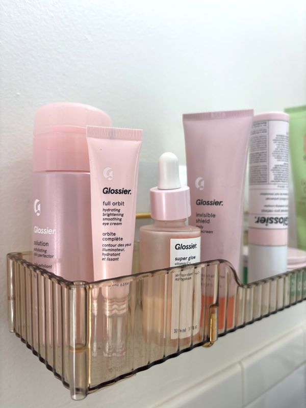 Pink skincare products arranged on a vanity