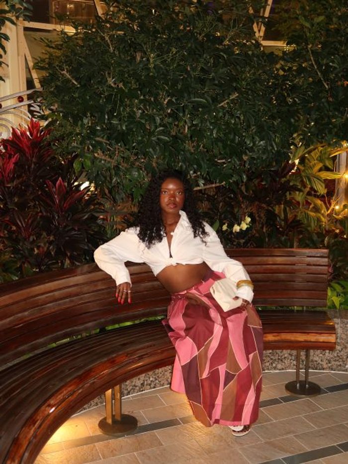 Juliana wearing a white top and patterned pink pants