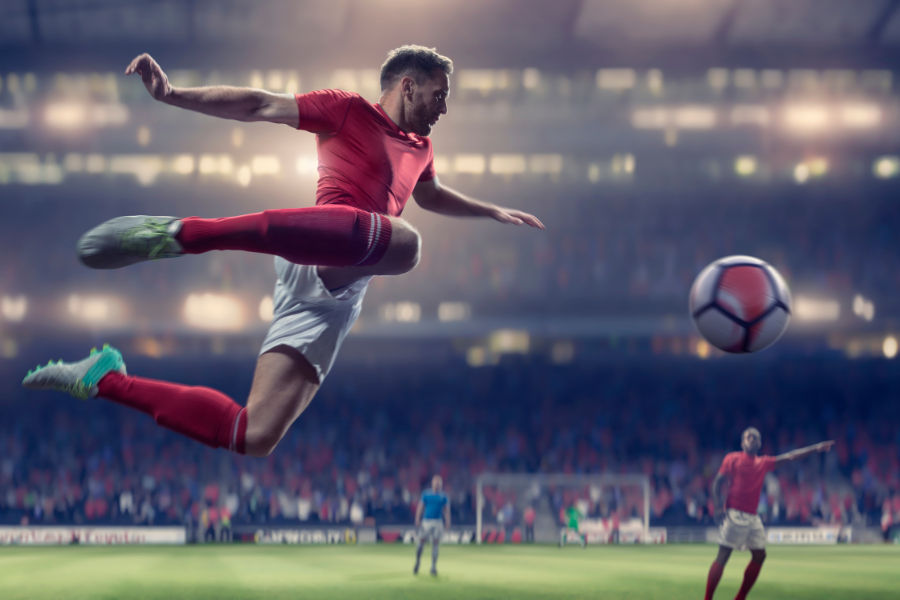 a person kicking a football in a football match