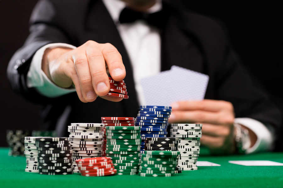 A person playing poker, holding poker chips 