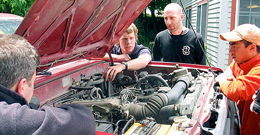 A team from a non-profit design group poring over a 1986 Toyota 4Runner to use in building an incubator [Image from the International Herald Tribune]