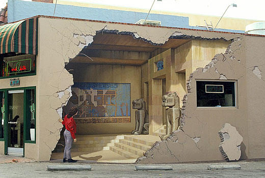 Fantastic optical illusion — the blown off wall, the Egyptian stuff and the woman peering in are all drawn!