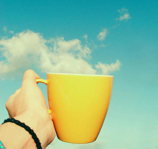 Superb shot of a cup with clouds in the background that seem to come out like steam from the cup