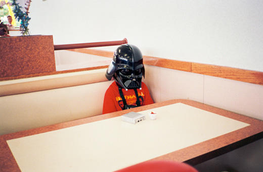 Sadly beautiful picture of a boy wearing a Darth Vader mask, sitting alone