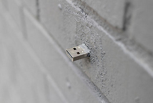 Aram Bartholl 'injects' USB flash drives into walls, buildings and curbs accessible to anybody in public space