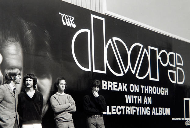 The Doors standing outside a billboard promoting their album in 1967