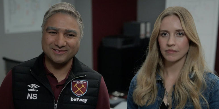 Nick Mohammed smiling awkwardly as Nathan Shelley standing next to a serious-looking Edyta Budnik as Jade in Ted Lasso