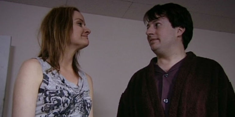 Natasha Beaumont smiling at an uncomfortable-looking David Mitchell as Mark Corrigan in Peep Show