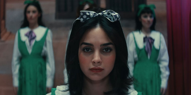 Laura in a green outfit and bow stares into the distance in Your Monster