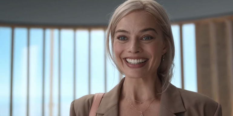 Margot Robbie smiling in the final scene of Barbie (2023).