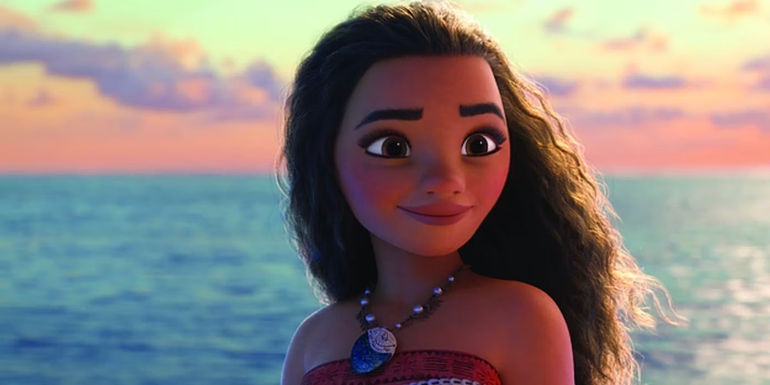 Moana smiling with the sunset and ocean in the background in Moana.