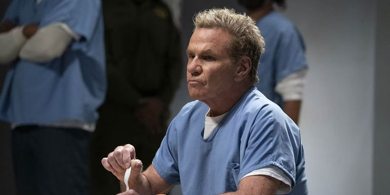 John Kreese siting and eating in jail in a scene from Cobra Kai.