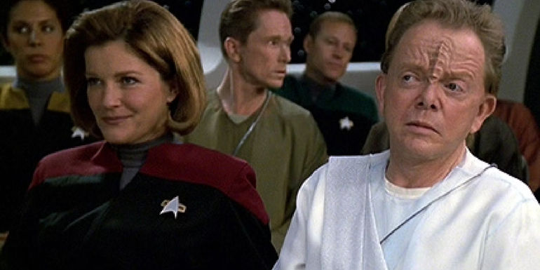 Kate Mulgrew and Paul Williams as Janeway and Koru, watching a musical performance