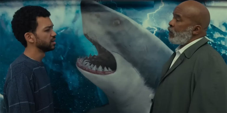 Justice Smith & David Alan Gier in front of a shark in The American Society of Magical Negroes