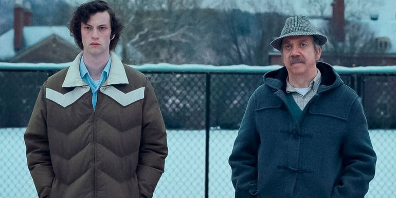 Dominic Sessa as Angus Tully and Paul Giamatti as Paul Hunham in the snow in The Holdovers