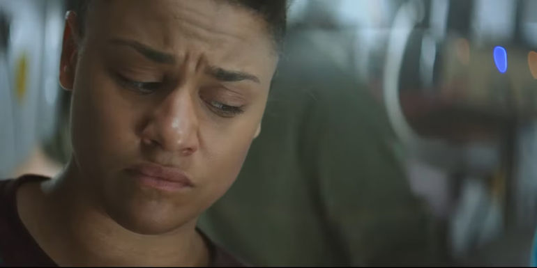 Ariana DeBose's Kira has an upset expression while looking down in I.S.S.