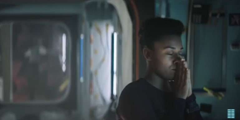 Kira has her hands up to her face and her eyes are closed in I.S.S.