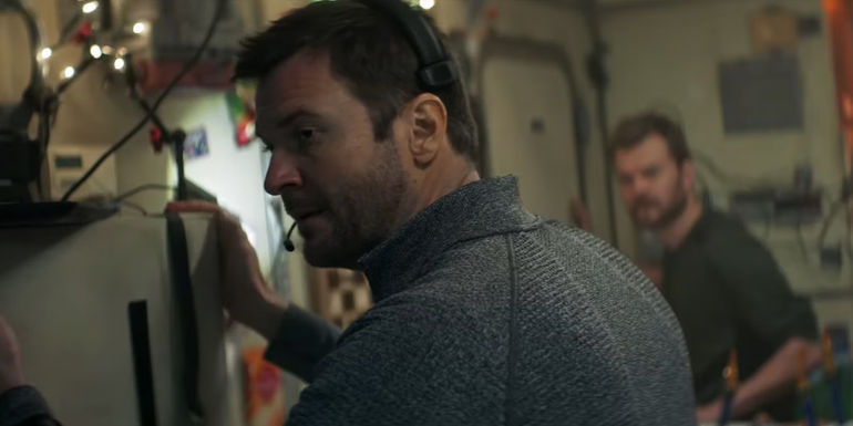 Nicholai looks over his shoulder while wearing a headset in I.S.S.