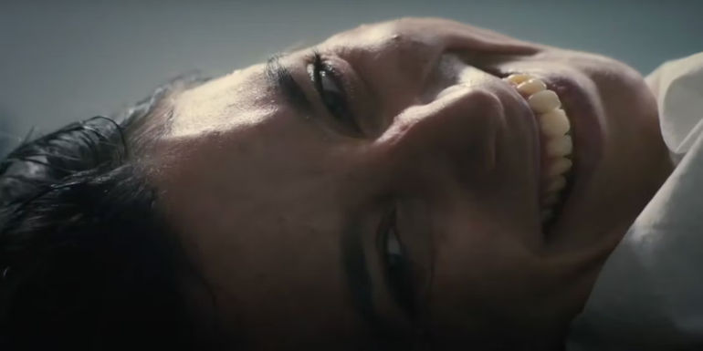 A creepy smiling woman in The First Omen