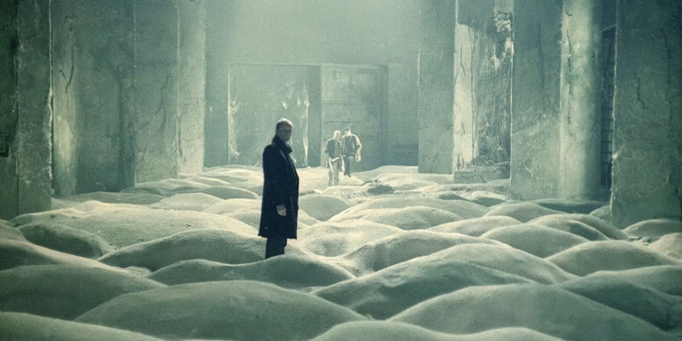 Men standing in a room full of sand in Stalker