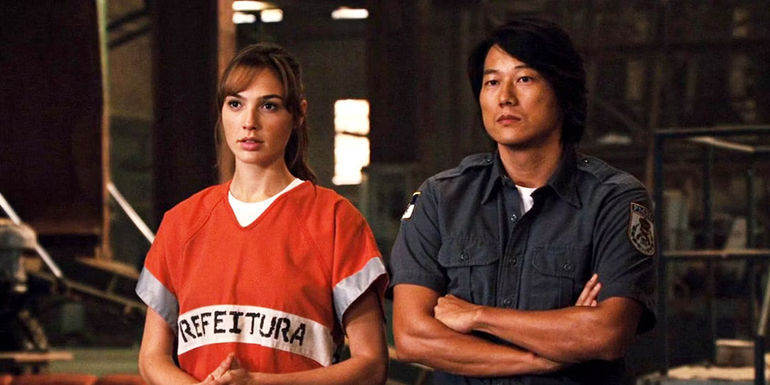 Gisele and Han standing next to one another in a garage in the Fast and Furious franchise