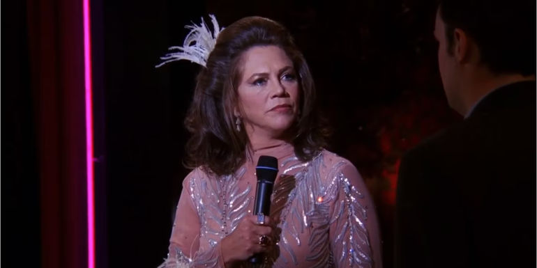 Kathleen Turner as Chandler's Dad dressed in drag with a mic in Friends