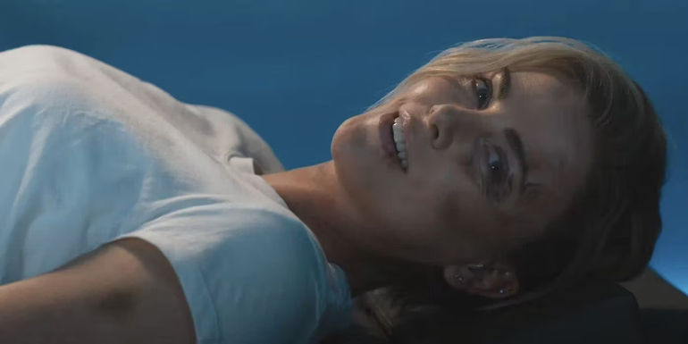 Cipher (Charlize Theron) laying and laughing in Fast X