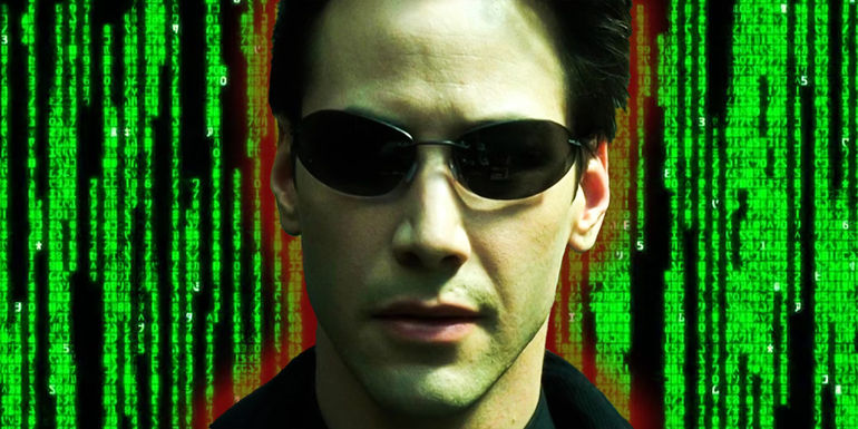 Keanu Reeves as Neo in his black glasses in front of green code from The Matrix