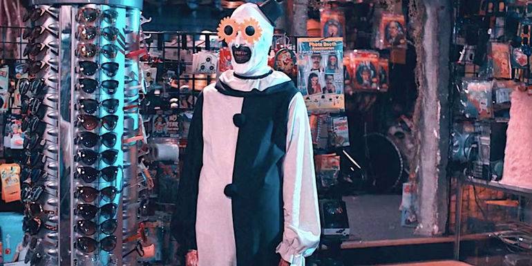 David Howard Thornton's Art the Clown stands in a store wearing goofy glasses in Terrifier 2-1