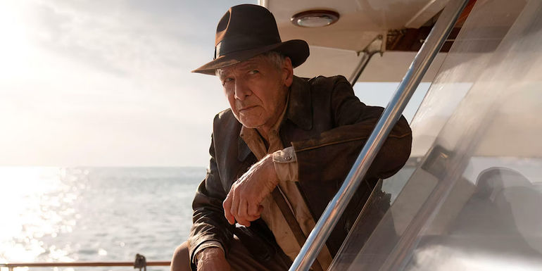 Indiana Jones leans his forearm on a ship in Indiana Jones and the Dial of Destiny.