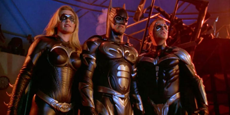 George Clooney, Chris O'Donnell, and Alicia Silverstone standing next to each other in costume in Batman and Robin